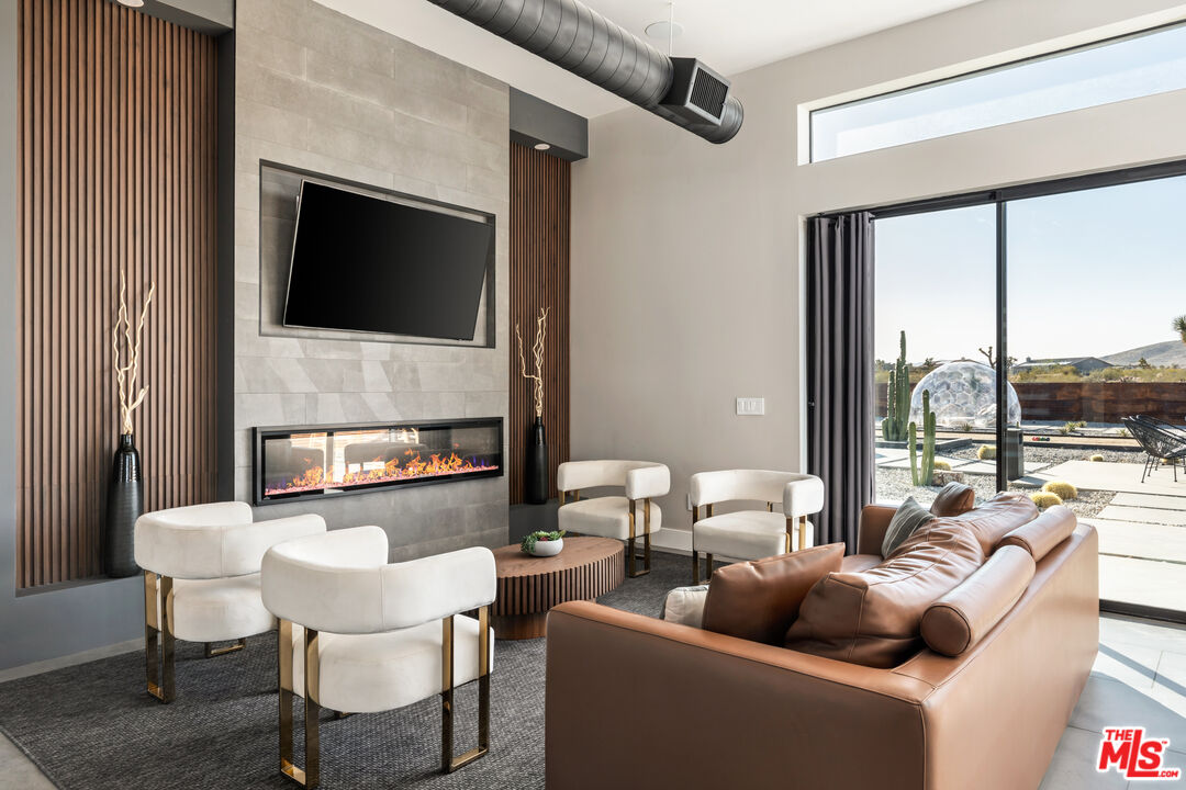 3000 Rockwood Road Joshua Tree, CA 92252 - Photo 14 of 71 a living room with furniture a fireplace and a flat screen tv