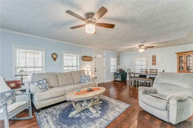 a living room with furniture a clock on wall and a window