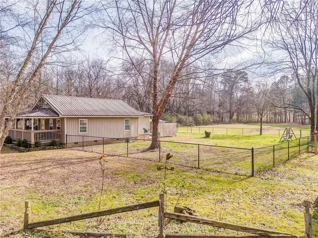 a view of a house with swimming pool and a yard