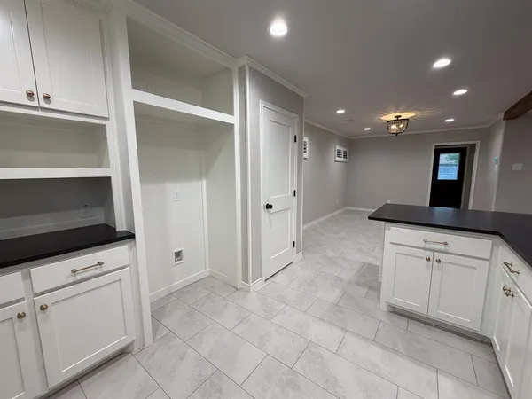 a open kitchen with white cabinets and stainless steel appliances