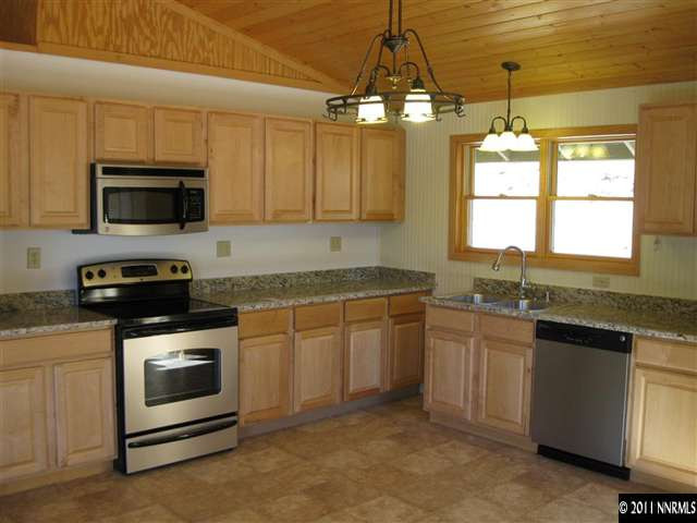 2830 Goldfield Road Reno, NV 89521 - Photo 2 of 13 a kitchen with granite countertop a stove sink and microwave