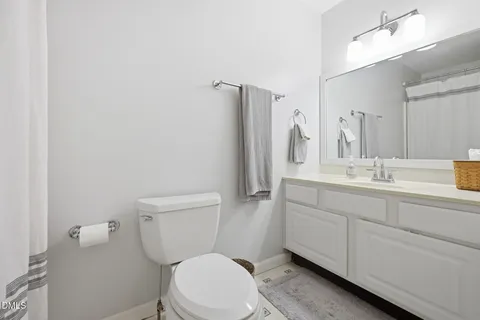 a bathroom with a sink a toilet a mirror and shower