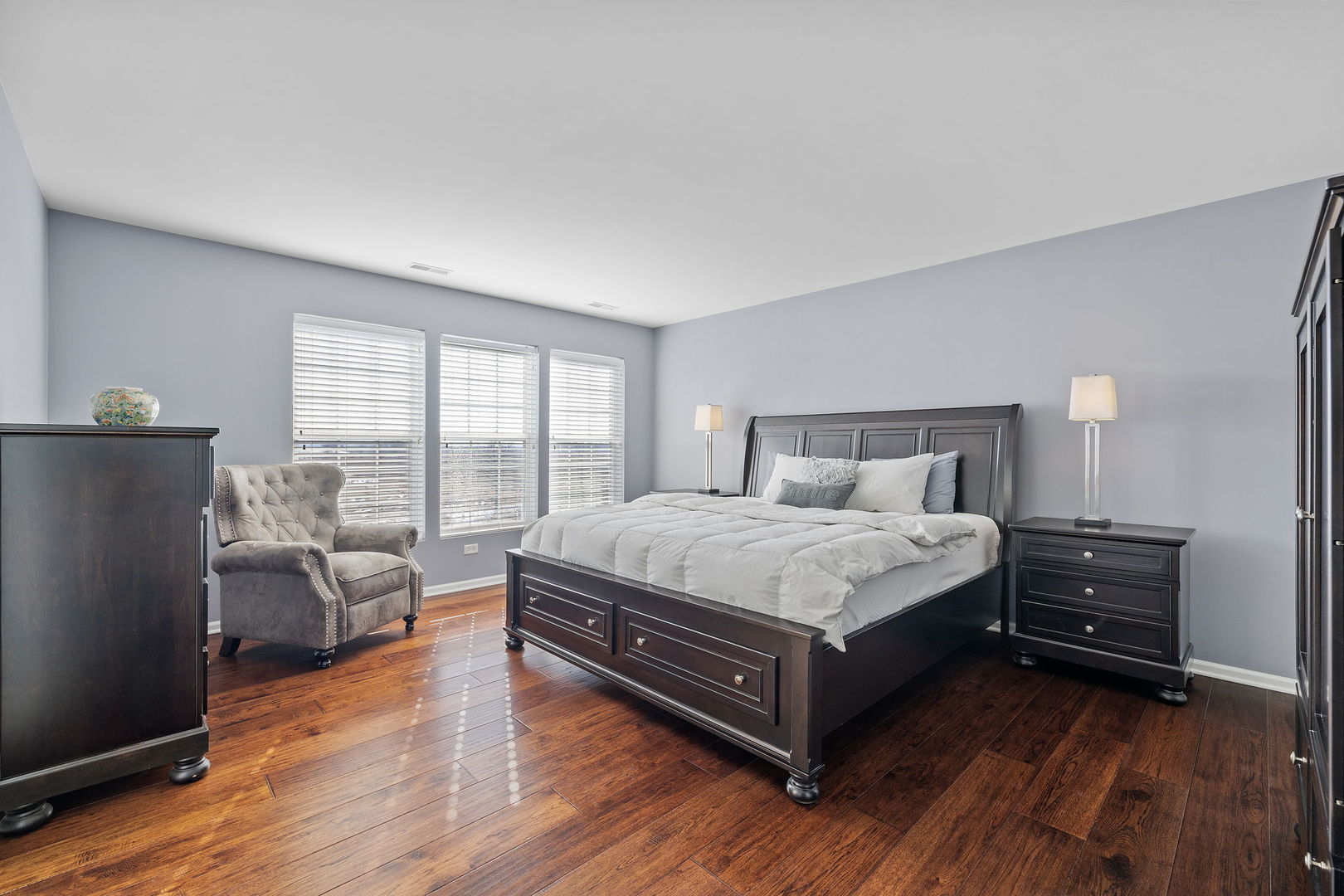 15341 Pinewood Road, Unit 15341 Lockport, IL 60441 - Photo 12 of 21 a bed sitting in a spacious bedroom next to a window with wooden floor