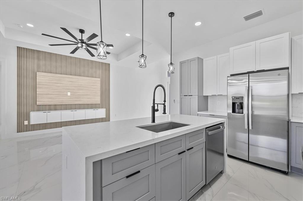 3812 9th Street Southwest Lehigh Acres, FL 33976 - Photo 10 of 39 a kitchen with stainless steel appliances a refrigerator sink and microwave