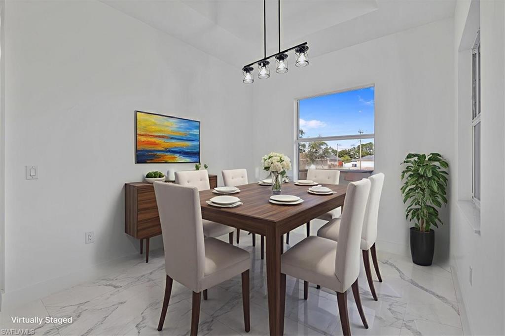 3812 9th Street Southwest Lehigh Acres, FL 33976 - Photo 12 of 39 a view of a dining room with furniture and a chandelier