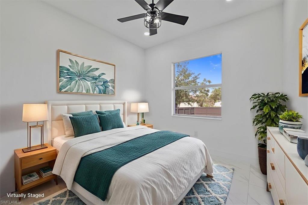 3812 9th Street Southwest Lehigh Acres, FL 33976 - Photo 25 of 39 a bedroom with a bed and a chandelier