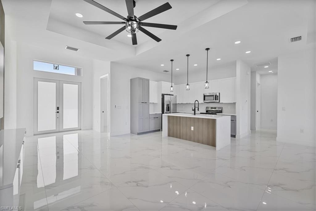 3812 9th Street Southwest Lehigh Acres, FL 33976 - Photo 39 of 39 a large white kitchen with kitchen island a island a sink stainless steel appliances and cabinets