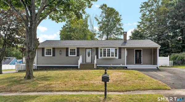 a front view of a house with a yard porch and tree