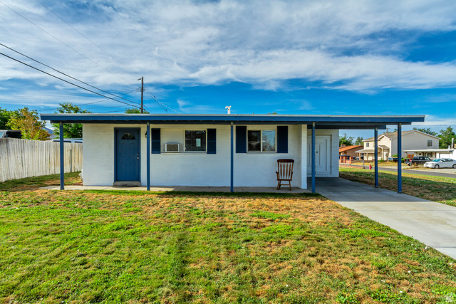 730 Geranium Street Sandy, UT 84094 - Photo 26 of 35 White exterior with blue trim and shutters, covered entryway, and an attached carport
