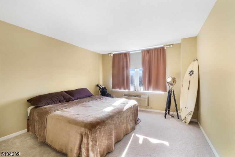 300 Main Street, Unit 416 Little Falls, NJ 07424 - Photo 11 of 19 a bedroom with a bed and a window