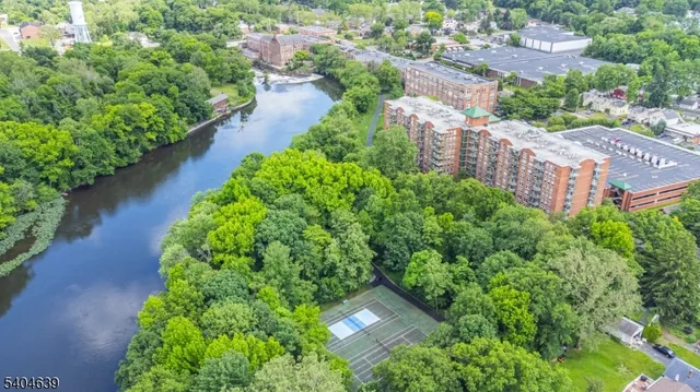 an aerial view of residential house with outdoor space and trees all around