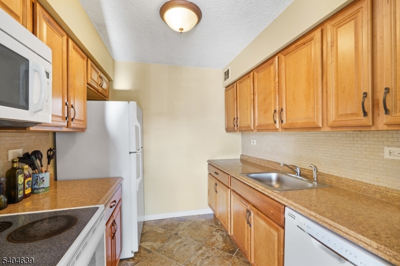 300 Main Street, Unit 416 Little Falls, NJ 07424 - Photo 9 of 19 a kitchen that has a sink and a stove