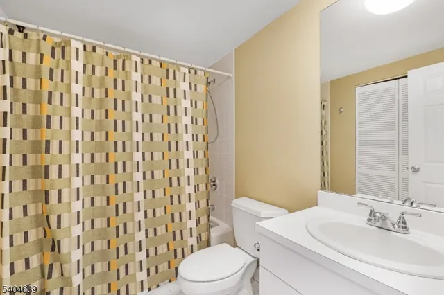 a bathroom with a sink a toilet and shower curtain