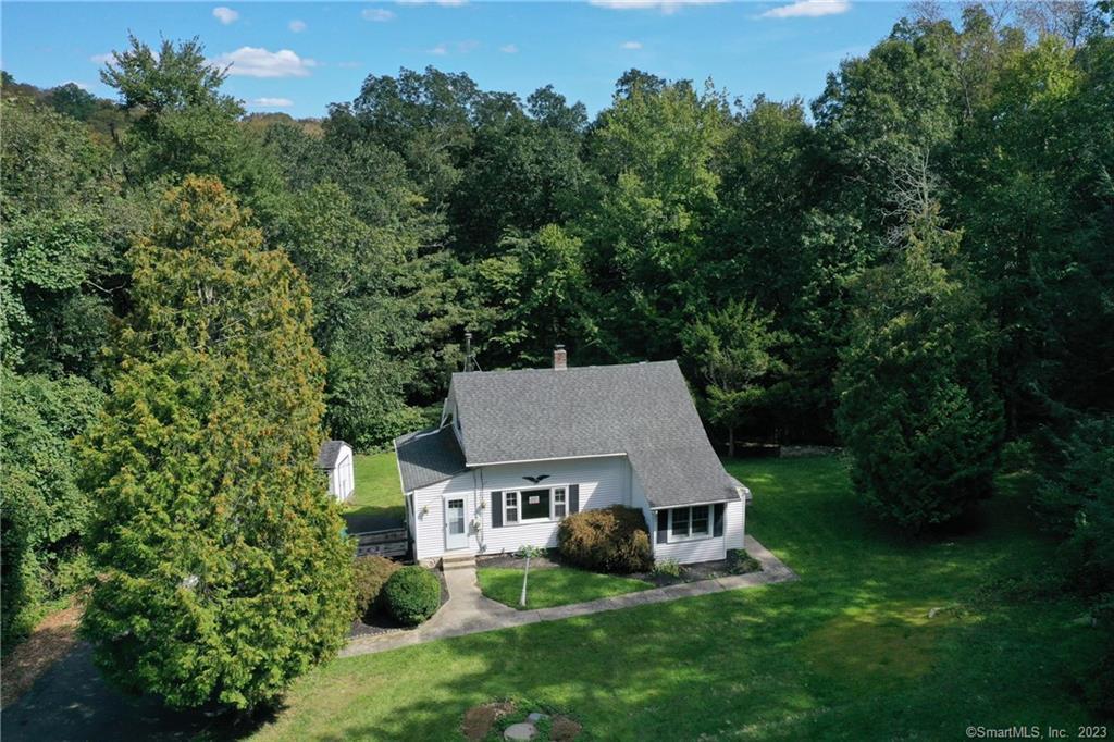 10 Spruce Hill Road Weston, CT 06883 - Photo 1 of 1 an aerial view of a house with yard and trees in the background