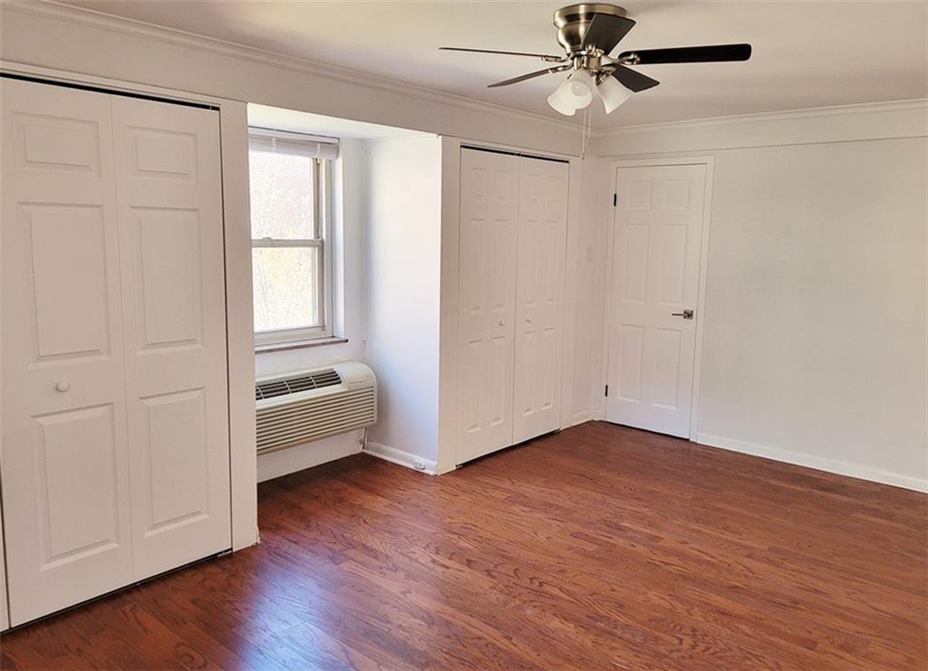 4601 Fifth Avenue, Unit 326 Pittsburgh, PA 15213 - Photo 14 of 20 an empty room with wooden floor fan and windows