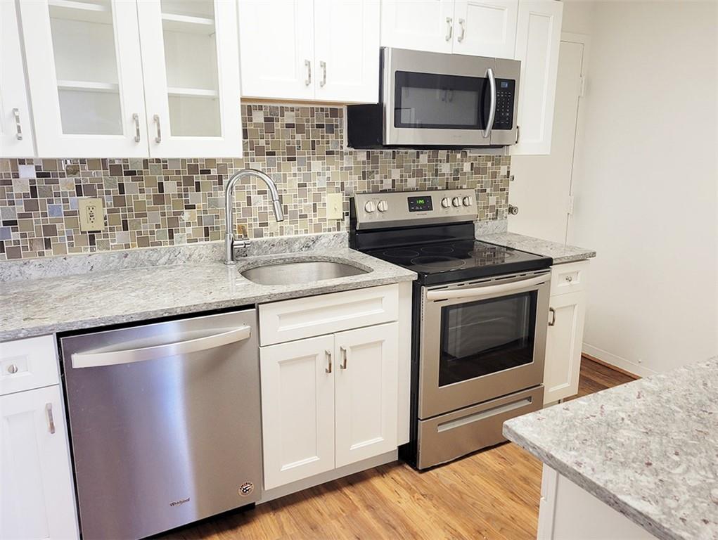 4601 Fifth Avenue, Unit 326 Pittsburgh, PA 15213 - Photo 8 of 20 a kitchen with stainless steel appliances granite countertop a stove microwave and sink