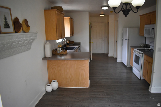 3327 East Windhover Road Eagle Mountain, UT 84005 - Photo 8 of 38 Kitchen area featuring wood-finish flooring, light wood cabinetry, white appliances, dark countertops, and a peninsula with seating space
