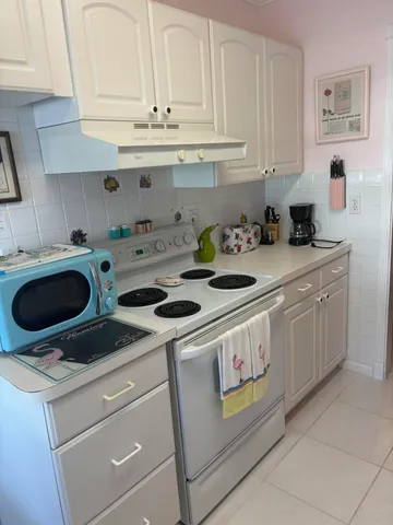 a kitchen with kitchen island granite countertop a sink a stove and cabinets