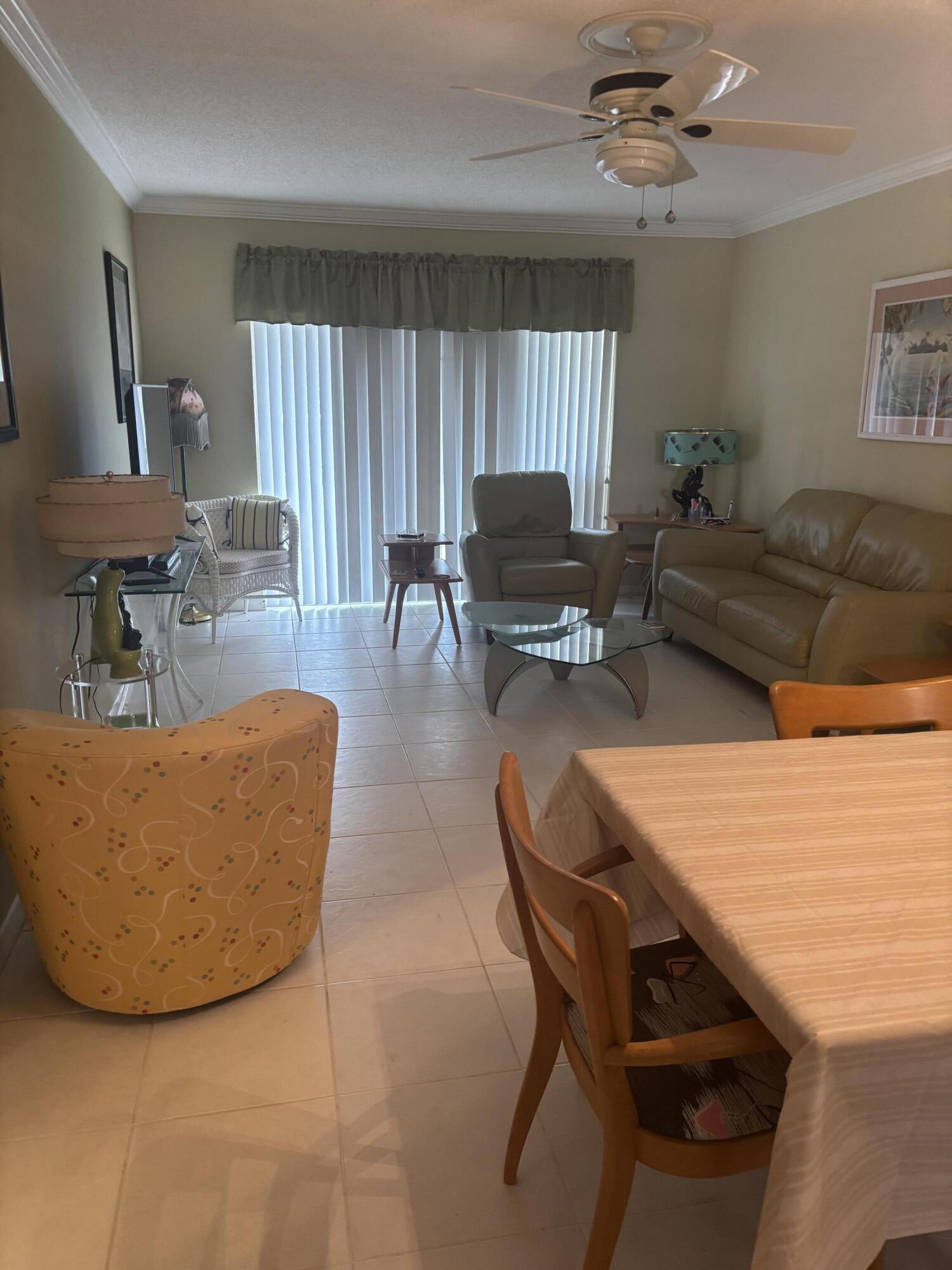 8608 Bella Vista Drive Boca Raton, FL 33433 - Photo 6 of 11 a living room with furniture a large window and a flat screen tv