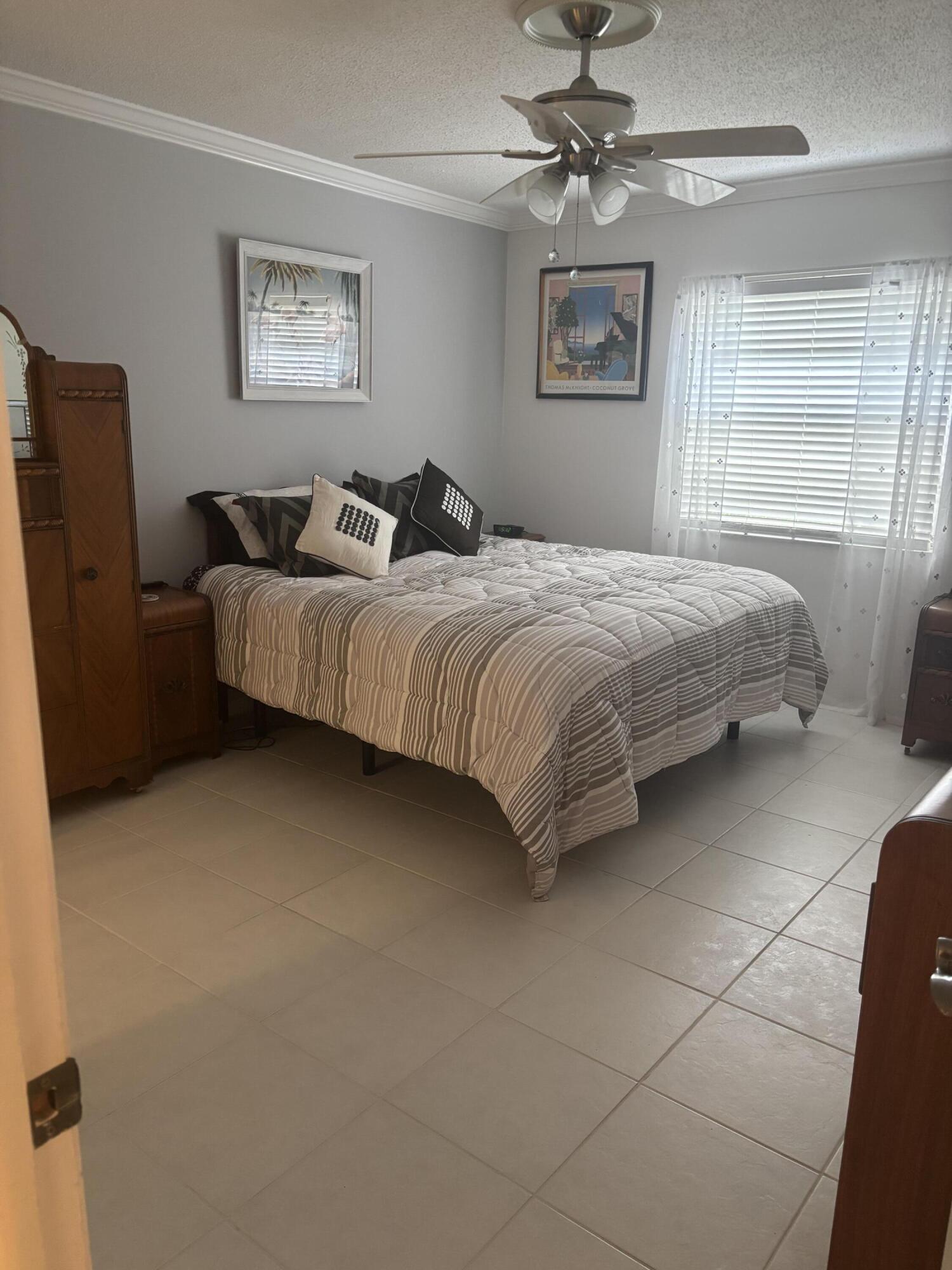 8608 Bella Vista Drive Boca Raton, FL 33433 - Photo 7 of 11 a bedroom with a bed and a painting on the wall