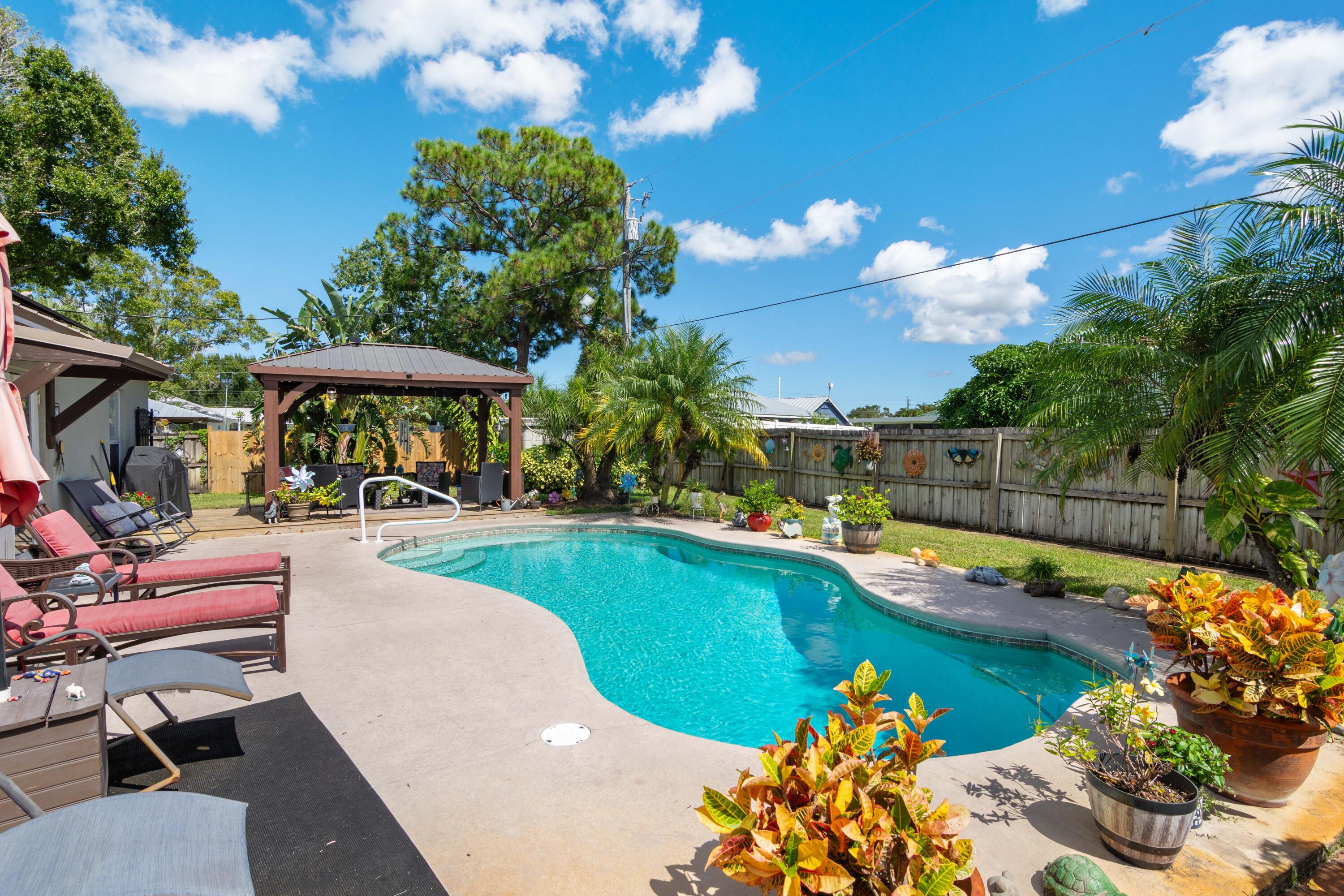 1817 Southwest Davis Street Port St. Lucie, FL 34953 - Photo 33 of 52 a view of a swimming pool with lounge chairs in patio