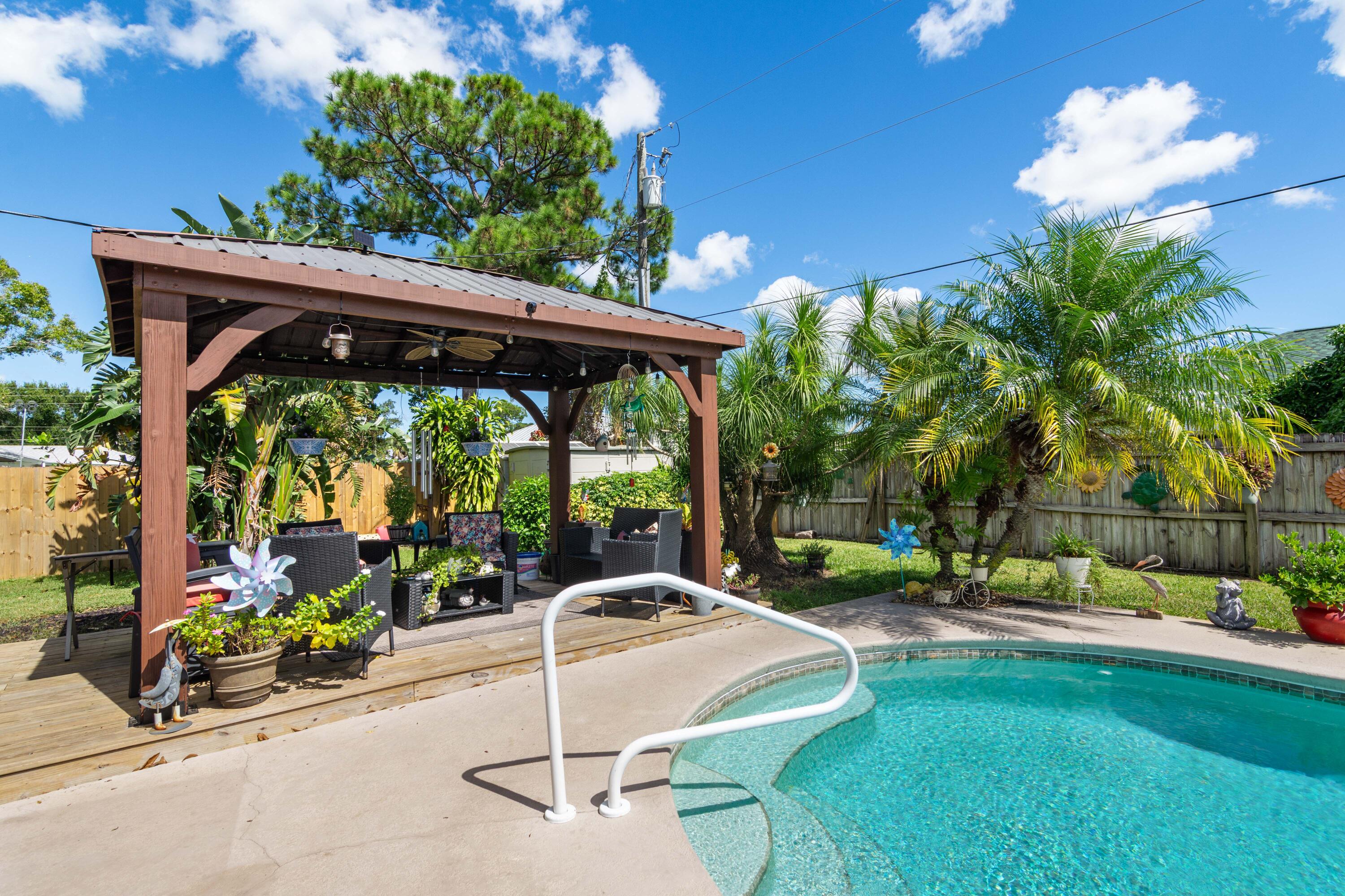 1817 Southwest Davis Street Port St. Lucie, FL 34953 - Photo 36 of 52 a view of a patio with a table chairs and a yard