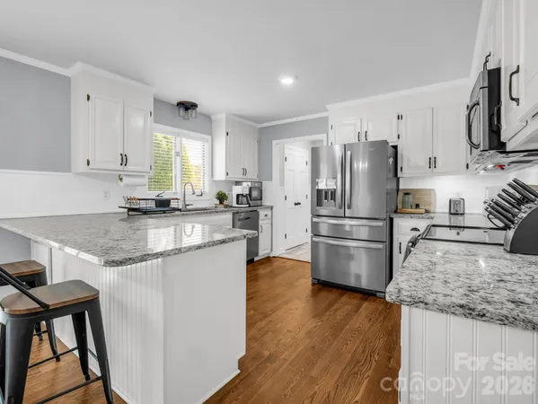 a kitchen with granite countertop a refrigerator and a stove top oven