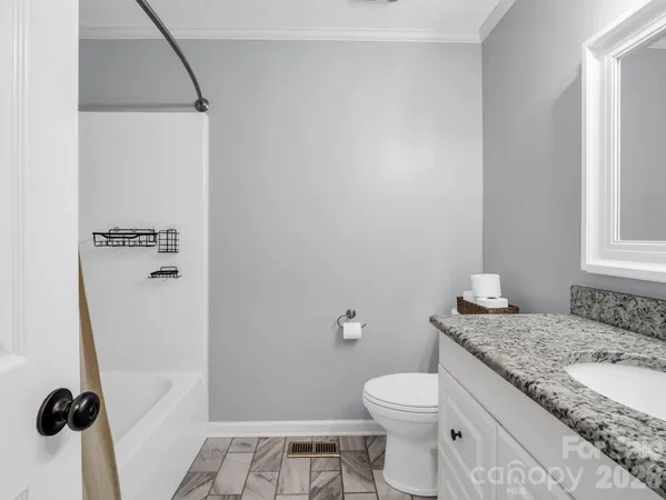 a bathroom with a granite countertop sink toilet and shower