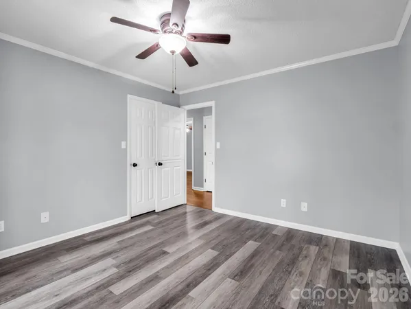 a view of an empty room and chandelier fan