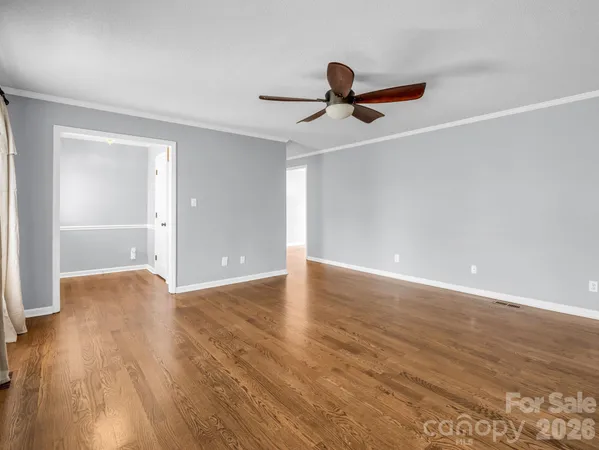a view of an empty room with wooden floor