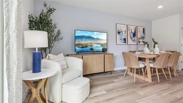 a living room with stainless steel appliances kitchen island granite countertop furniture and a wooden floor