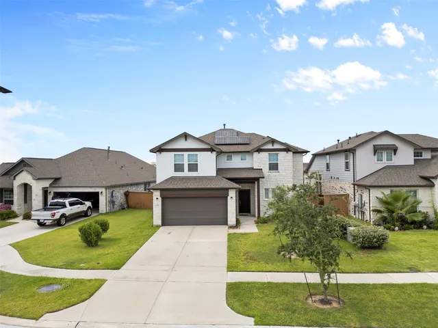 a front view of a house with a yard and garage