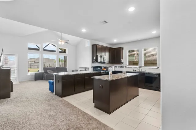 a kitchen with granite countertop a sink a counter top space appliances and cabinets