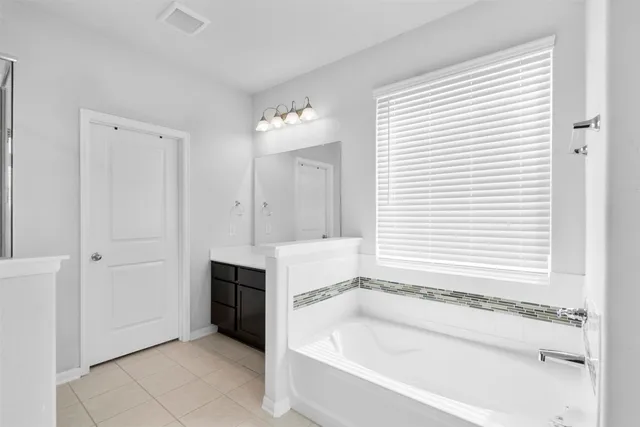 a spacious bathroom with a bathtub and a sink
