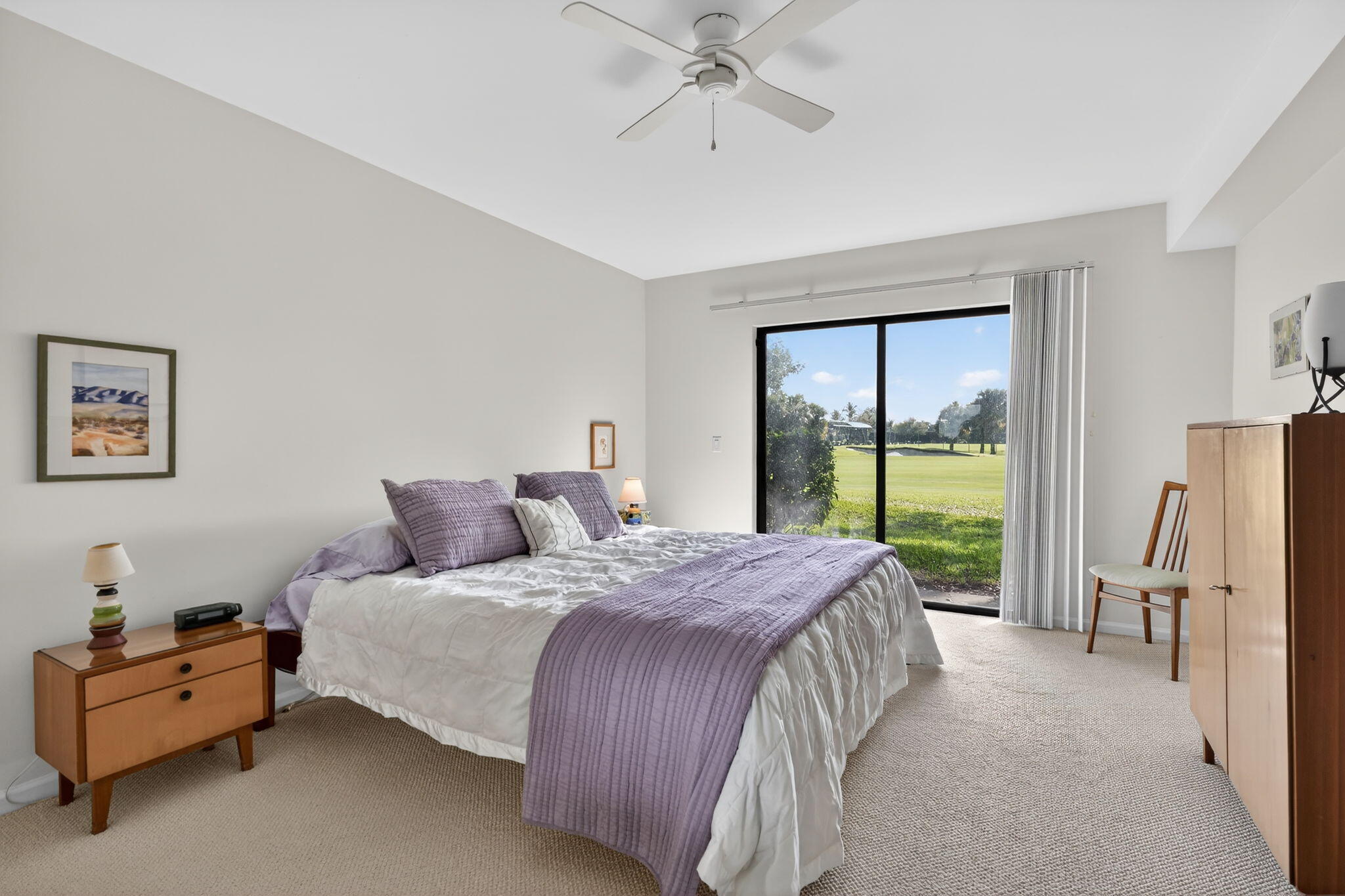 16670 Traders Crossing North, Unit 110 Jupiter, FL 33477 - Photo 13 of 22 a bedroom with a bed flat screen tv and a large window
