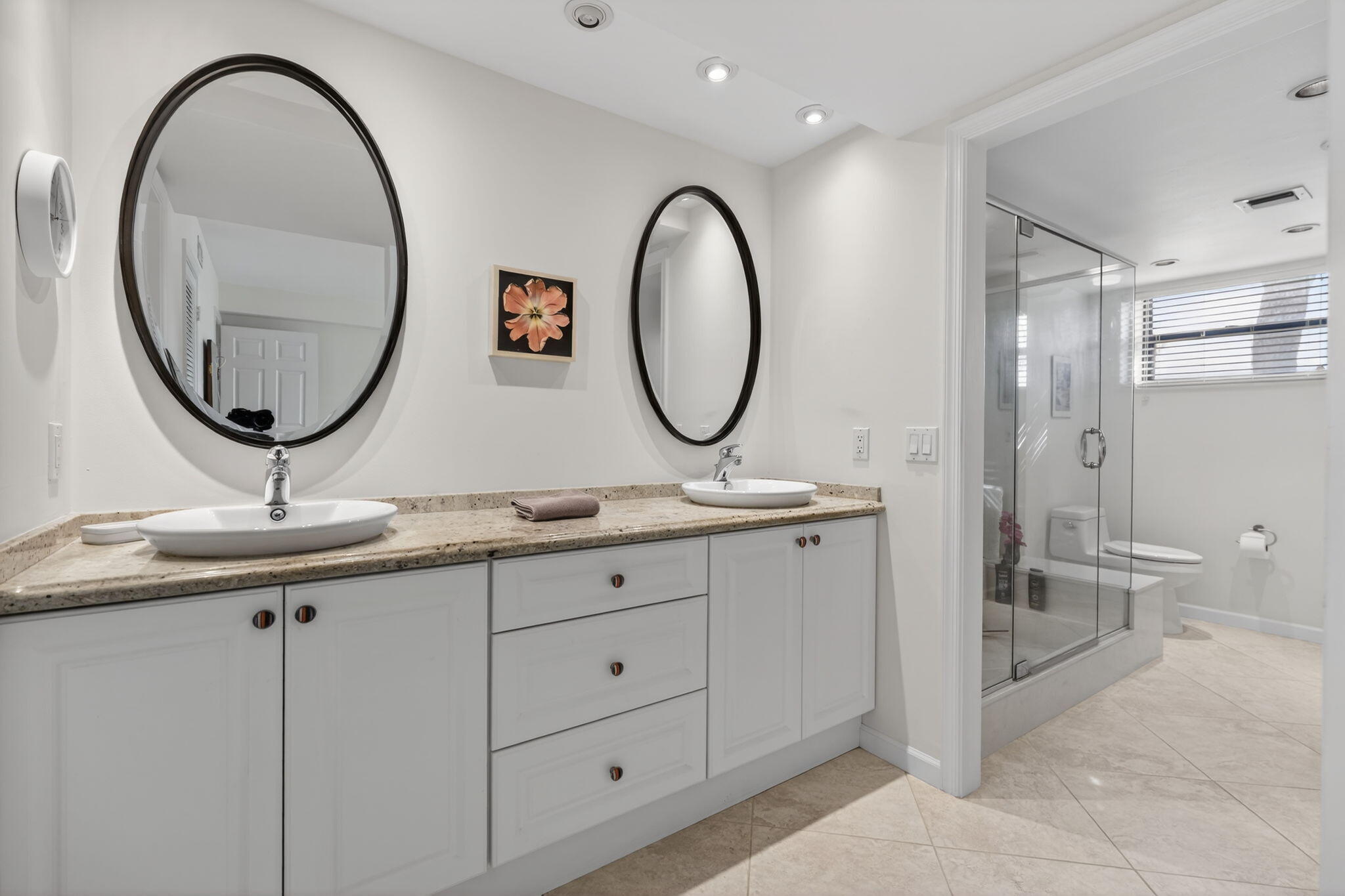 16670 Traders Crossing North, Unit 110 Jupiter, FL 33477 - Photo 14 of 22 a bathroom with a granite countertop toilet a sink and a mirror