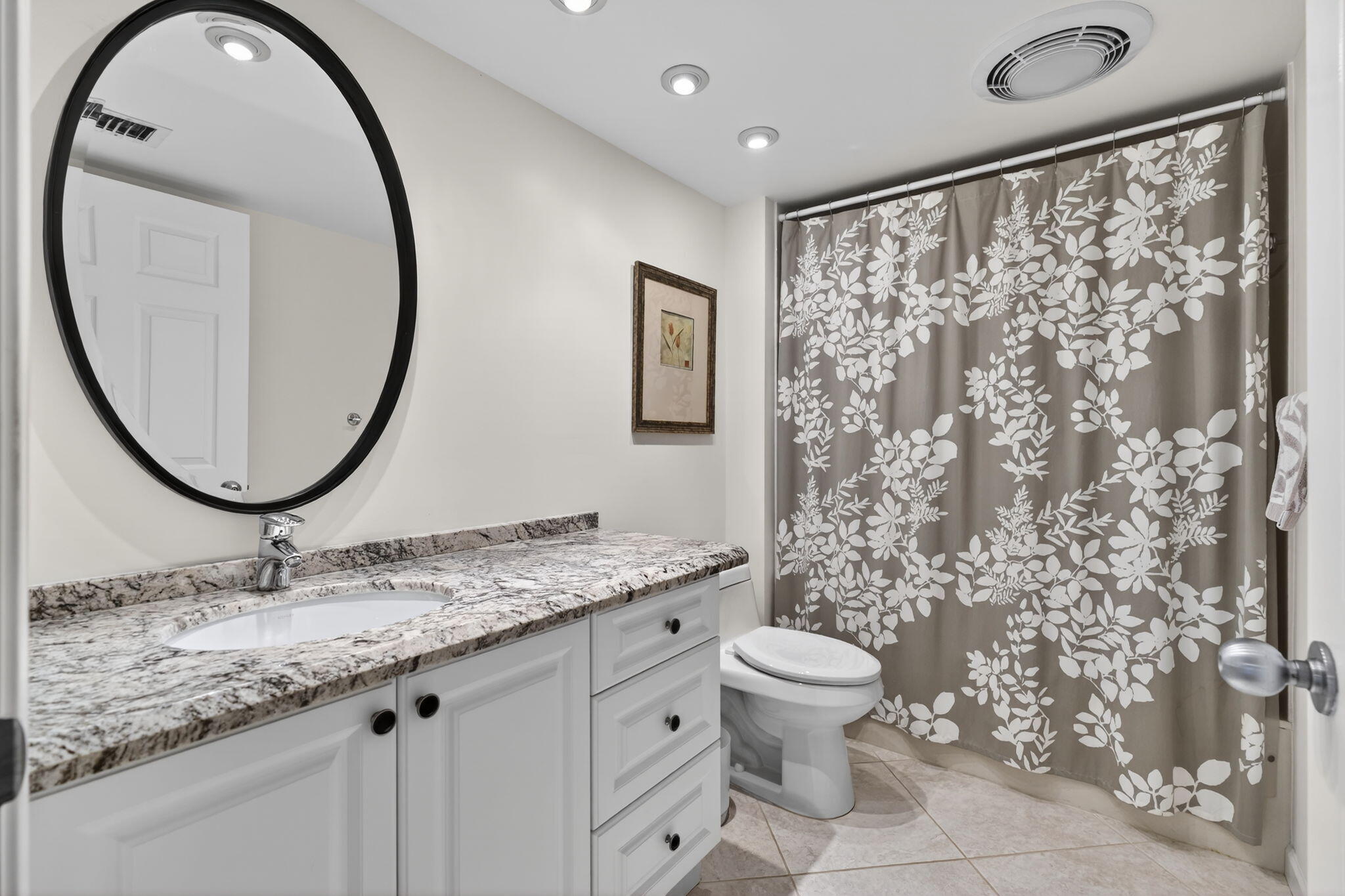 16670 Traders Crossing North, Unit 110 Jupiter, FL 33477 - Photo 16 of 22 a bathroom with a granite countertop sink and a mirror