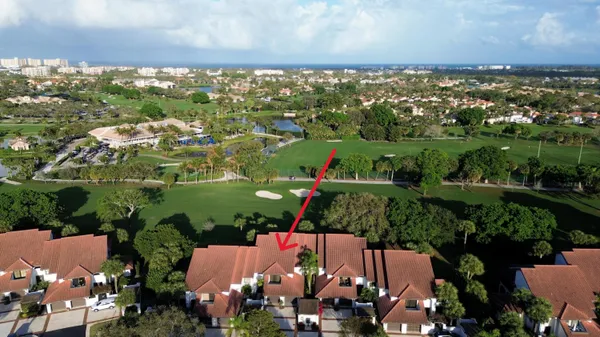 an aerial view of residential houses with outdoor space and trees