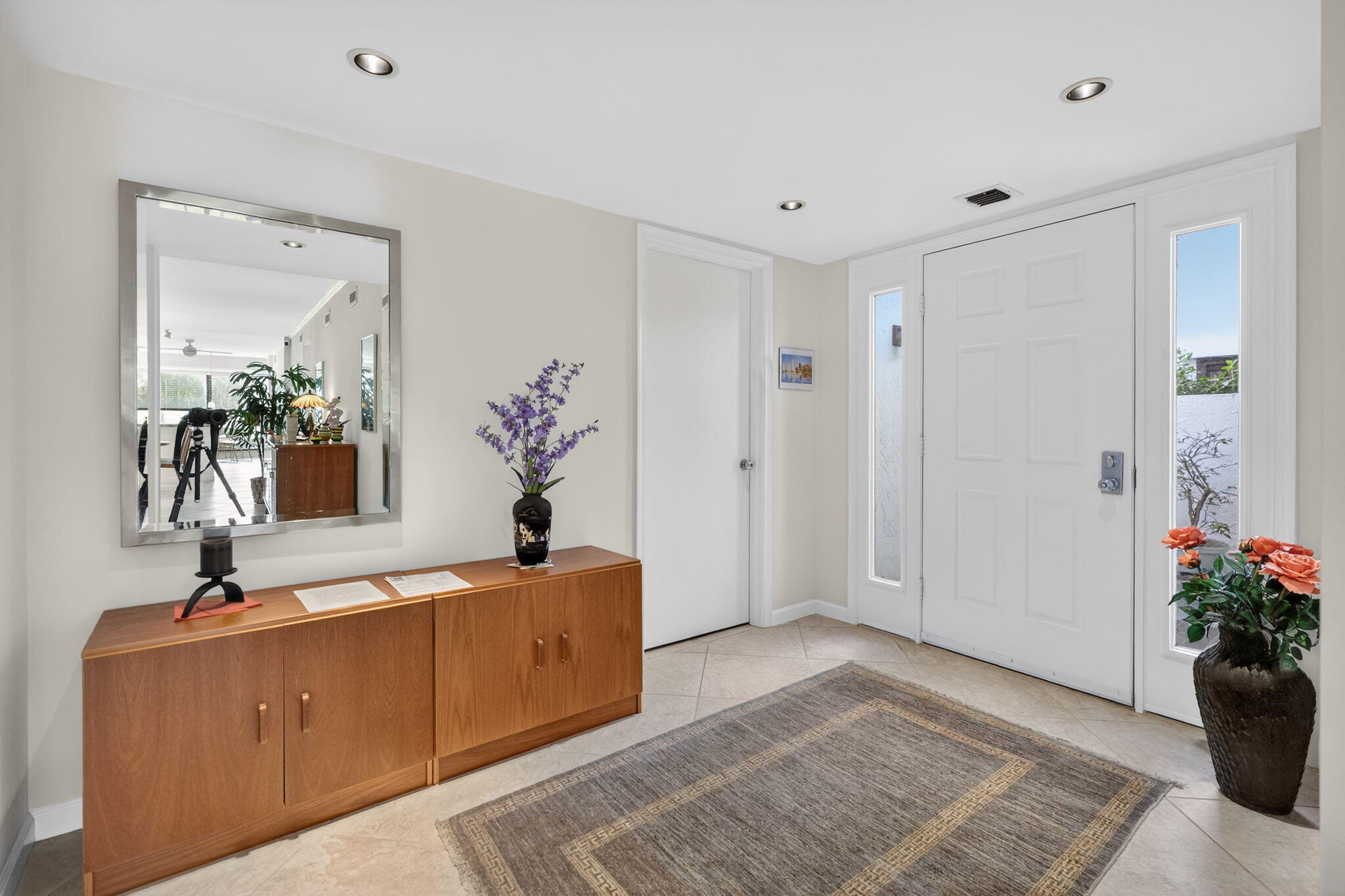16670 Traders Crossing North, Unit 110 Jupiter, FL 33477 - Photo 3 of 22 a living room with furniture and flowers