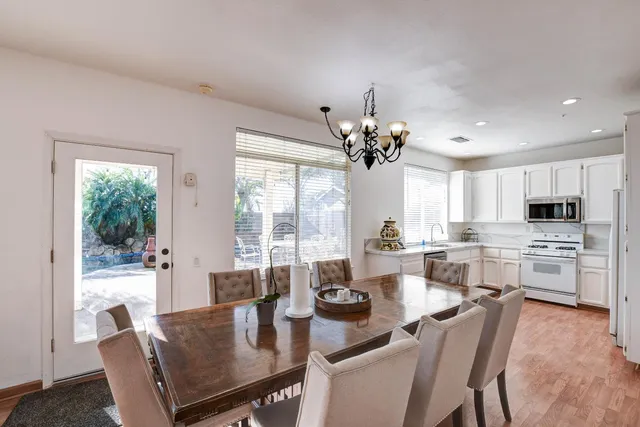 a view of a dining room with furniture a chandelier and wooden floor