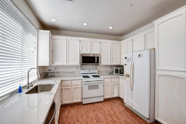 a kitchen with a sink a refrigerator a microwave and cabinets