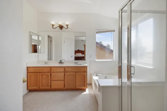 a spacious bathroom with a granite countertop sink a mirror and a bathtub