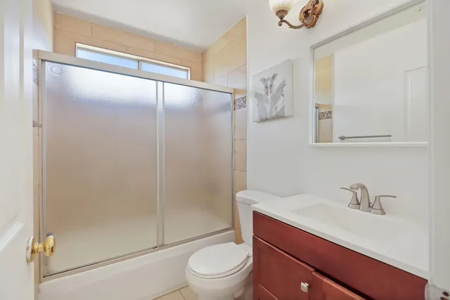 a bathroom with a sink a mirror a toilet and shower