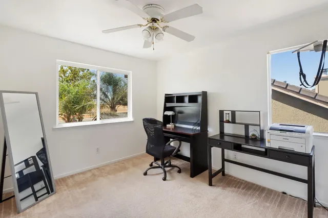 a view of a workspace with furniture and a window