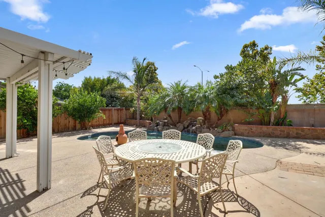 a view of a patio with a table and chairs under an umbrella