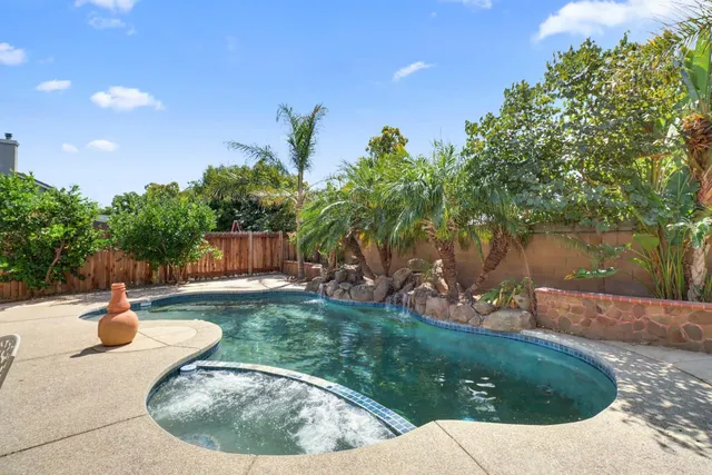a view of a swimming pool with a yard and plants