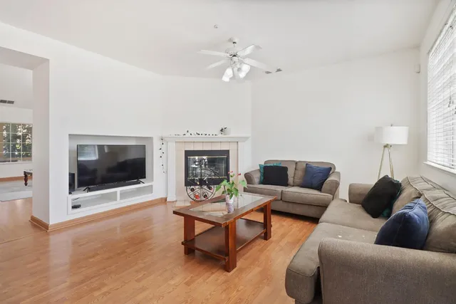 a living room with furniture a flat screen tv and a fireplace