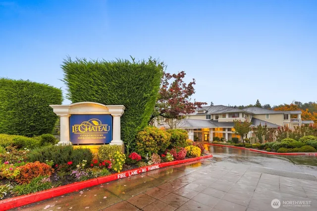 a view of a sign board with buildings in the background