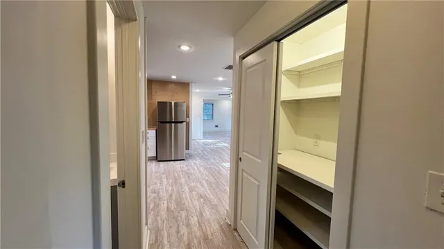 a view of a hallway with wooden floor and staircase