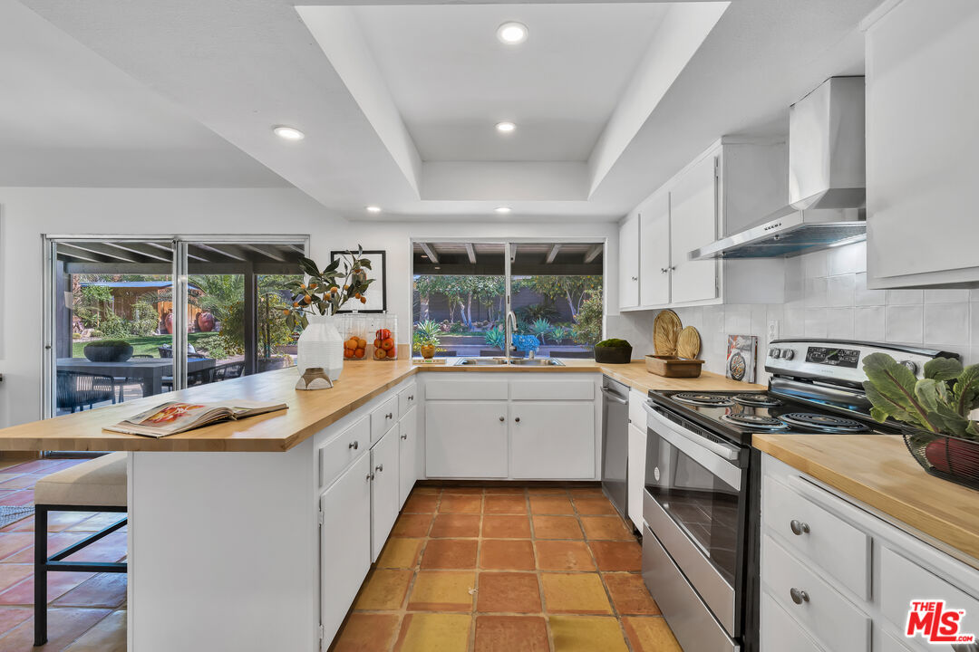 73589 Haystack Road Palm Desert, CA 92260 - Photo 14 of 54 a kitchen with a sink stove and cabinets